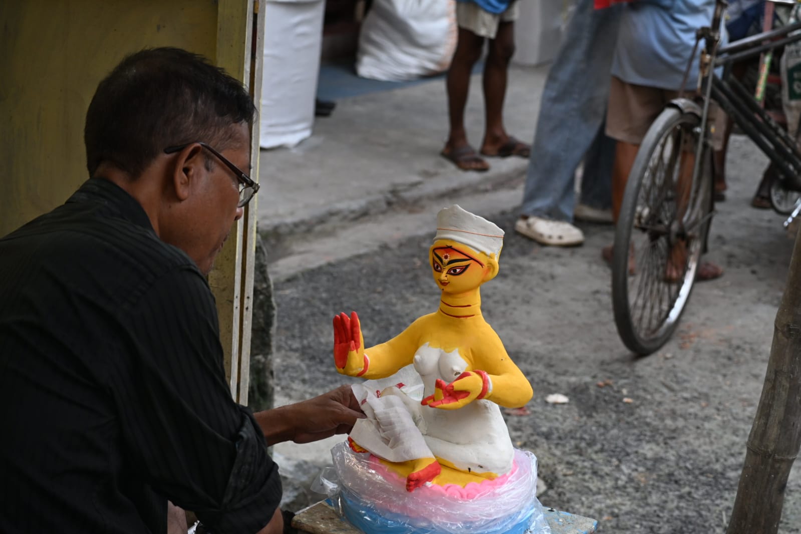 An artisan adding the final details to a small painted Durga